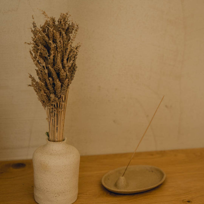 diffuser on plate next to white vase with herbal tea f zeen boutique